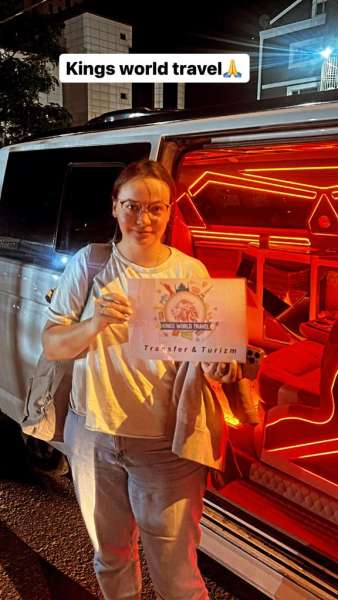 Πελάτης με πινακίδα Kings World Transfer τη νύχτα